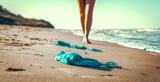 swimsuit in the sand on the beach near the sea surf on the background of a naked female figure and blue sky