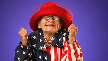 Wall Mural - Closeup portrait of toothless elderly senior old woman with wrinkled skin having great happy success winner wearing US flag jacket isolated on purple background. People emotions concept.