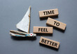 Time to feel better symbol. Wooden blocks with words Time to feel better. Beautiful grey background with boat. Medicine and Time to feel better concept. Copy space.