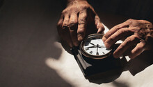 Elderly Man Holding Old And Antique Clock In His Hands Watches How Time Passes