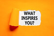 © Dzmitry - What inspires you symbol. Concept words What inspires you on beautiful white paper. Beautiful orange background. Business motivational what inspires you concept. Copy space.