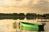 Fototapeta Pomosty - Łódka na jeziorze o zachodzie słońca