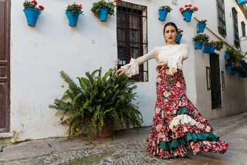 Feminine ethnic dancer performing flamenco on street