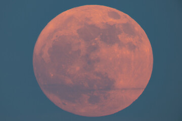 super strawberry moon rising over the sea, a reddish full moon rising over the sea on a summer night