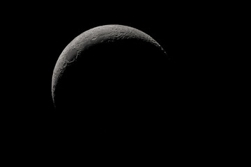 Wall Mural - crescent moon photographed with a telescope, where you can see the craters and the lunar surface, it
