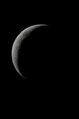 Wall Mural - crescent moon photographed with a telescope, where you can see the craters and the lunar surface, it
