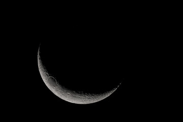 Wall Mural - crescent moon photographed with a telescope, where you can see the craters and the lunar surface, it