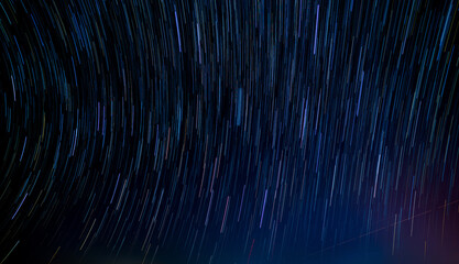 abstract photo of blue night sky star trail background.startrails on a dark blue sky at night,center