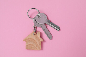 Wall Mural - Metallic keys with wooden keychain in shape of house on pink background, top view