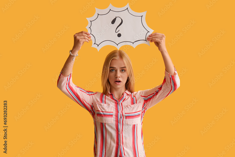 Young woman holding speech bubble with question mark on yellow background