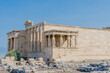 The Erechtheion, a temple of the Acropolis with blue sky in background.