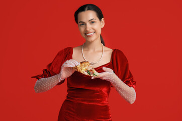 Poster - Beautiful young woman with slice of tasty pizza on red background