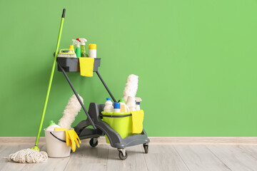 Wall Mural - Trolley with cleaning supplies near green wall