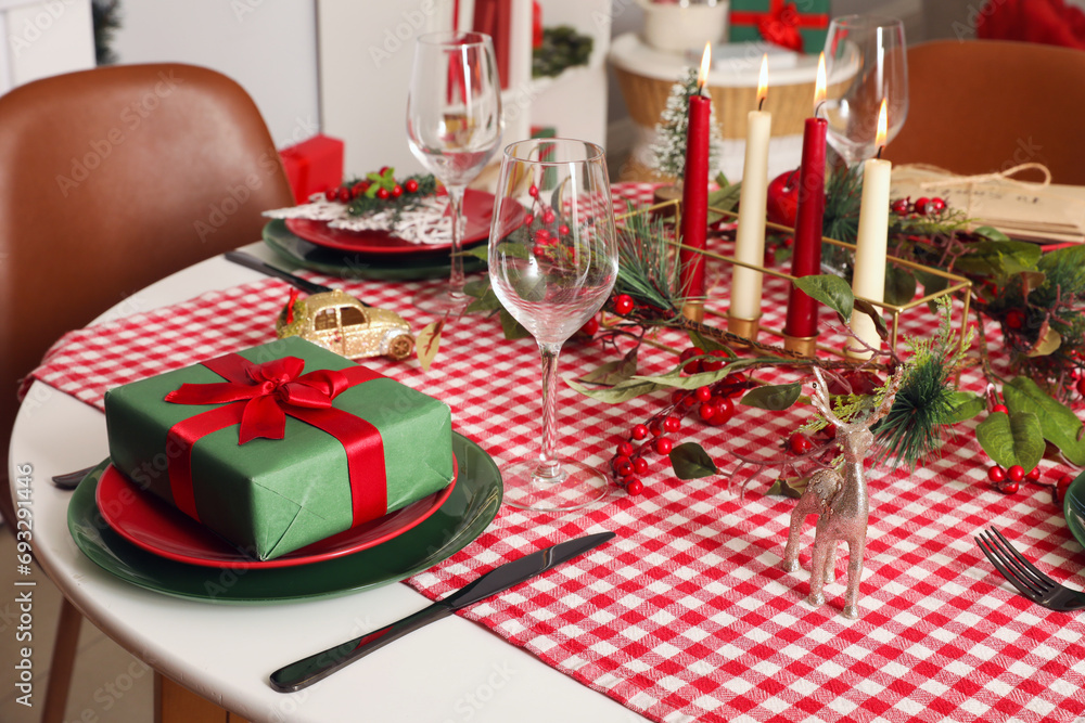 Table setting with Christmas decorations and gift in living room
