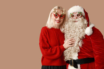 Sticker - Happy Santa Claus and beautiful mature woman in Christmas glasses on brown background