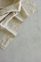 Wall Mural - Llinen napkin beige color top view on gray stone   background with copy space. Brand template, Neutral colors