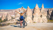 © M.studio - Woman with mountain bike enjoys Cappadocia landscape- Turkey