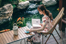 Young beauty sitting in the courtyard reading