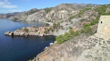 Wall Mural - Medieval watchtower next to cliffs on the Mediterranean coast. Reaviling aerial view of medieval ruins next to the stunning blue sea. Andalusia. Spain.