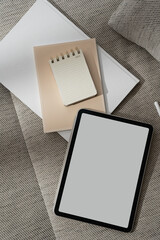 Wall Mural - tablet pad with blank copy space screen, notebook, documents on sofa. minimal online branding concep