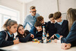 © Drobot Dean - Group of children and teacher making creative project with constructor at stem education class