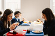 © Drobot Dean - Group of school children having lunch while sitting in school cafeteria