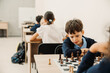 © Drobot Dean - Group of school kids learning to play chess in classroom
