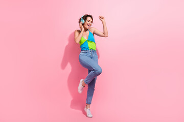 Poster - Full length cadre of charming hipster lady dance carefree touching her blue wireless earbuds loud sound isolated on pink color background