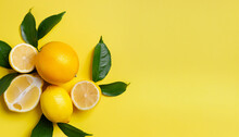 Fully Ripened Lemons, Vibrant Orange And Green Leaves On A Lively Yellow Background. Lemon Fruit, Citrus Minimalism, Vitamin C. Artistic Summer Minimalistic Scene. Flat Lay, Top View, Ample Space For 