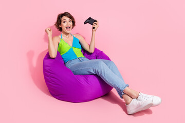 Sticker - Full length body photo of funny overjoyed gamer woman celebrating first win on her playstation console isolated on pink color background