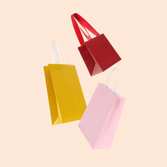 Poster - Colorful shopping bags falling on beige background