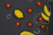 Photo combined with graphics:  vegetables and fruits falling out a black mesh, top view, grey background. 