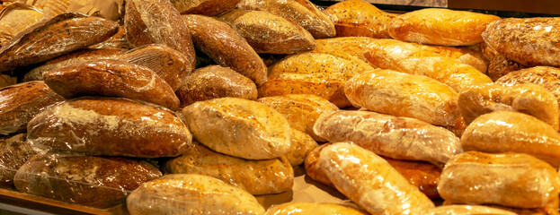 Lot of different bread packed in a film in the supermarket. Trade, shops, business