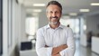 © Hope - Headshot close up portrait of indian or latin confident mature good looking middle age leader, ceo male businessman on blur office background. Handsome hispanic senior business man smiling at camera.