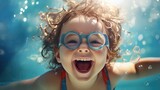 Fototapeta  - A child is having fun in the pool wearing safety glasses. Entertainment during the summer holidays.