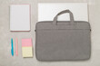 © Liami - Grey stylish laptop bag with stationery on concrete background,top view