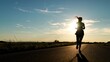 © Валерий Зотьев - silhouette sports girl running along road sunset, american woman running along road, urban marathon runner crossing finish line, confident motivated beautiful sportswoman, athletic woman running on