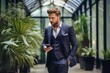 © Ilja - Businessman in formal attire using smartphone near office window for professional communication