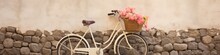 A Minimalist Photo Of A Bicycle With A Basket Full Of Fresh Summer Flowers Against A Rustic Wall