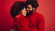 © Irina - Portrait of a young black couple hugging, smiling in red clothes on a red background. A man and a woman in love are enjoying Valentine's Day. The concept of a romantic relationship for a photo shoot.