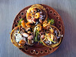 Delicious dish of Sopes and seafood tostadas that are a fried tortilla with beans, shrimp and octopus on top