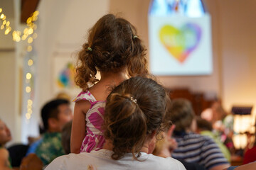 Mother child from behind watching carols church service Christmas