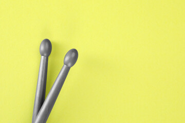 Wall Mural - Two gray drum sticks on light green background, top view. Space for text