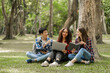 © M+Isolation+Photo - Group of young interracial diverse university students chatting together outside, engaging in a discussion together, college campus, enjoying campus recreation. Happy friends