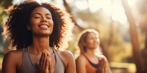 Wall Mural - women stretching arms outdoor. Yoga class doing breathing exercise at park. Beautiful fit women doing breath exercise together with outstretched arms.
