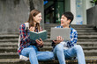© M+Isolation+Photo - Group of young interracial diverse university students chatting together outside, engaging in a discussion together, college campus, enjoying campus recreation. Happy friends