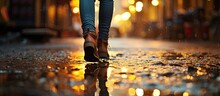 Post-rain, A Blurred Image Of A Woman Walking Is Mirrored In A Wet Pavement Puddle.