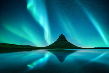 Wall Mural - reflection of kirkjufell mountain and northern lights in starry sky in clear lake water near kirkjuf