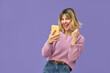 Excited crazy gen z blonde young woman winner with smartphone, happy shopper customer student girl screaming yes using mobile cell phone celebrating online prize win on purple background.