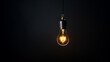 Ampoule faiblement éclairée dans une pièce sombre, fond noir. Lumière, électricité. Pour conception et création graphique.